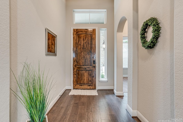 2714 Trailmont Dr, San Antonio, TX 78253 - entryway with arched walkways, dark wood-style floors, baseboards, a textured wall, and a towering ceiling
