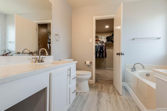 20827 Foothill Pne, San Antonio, TX 78259 - full bathroom with vanity, a bath, a spacious closet, wood finished floors, and toilet