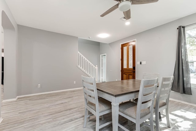 20827 Foothill Pne, San Antonio, TX 78259 - dining area with light wood-style floors, a ceiling fan, stairway, arched walkways, and baseboards