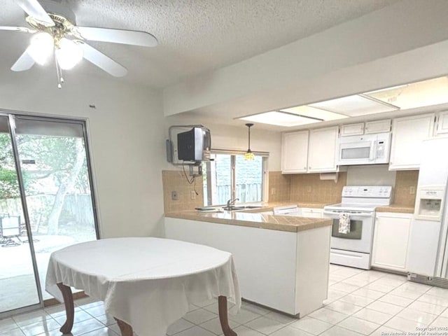8526 Timberwilde, San Antonio, TX 78250 - kitchen featuring white appliances, a peninsula, decorative backsplash, light countertops, and white cabinets