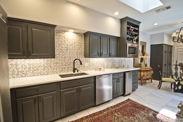 8 Kensington Ct, San Antonio, TX 78218 - kitchen with stainless steel appliances, a sink, a skylight, backsplash, and light countertops