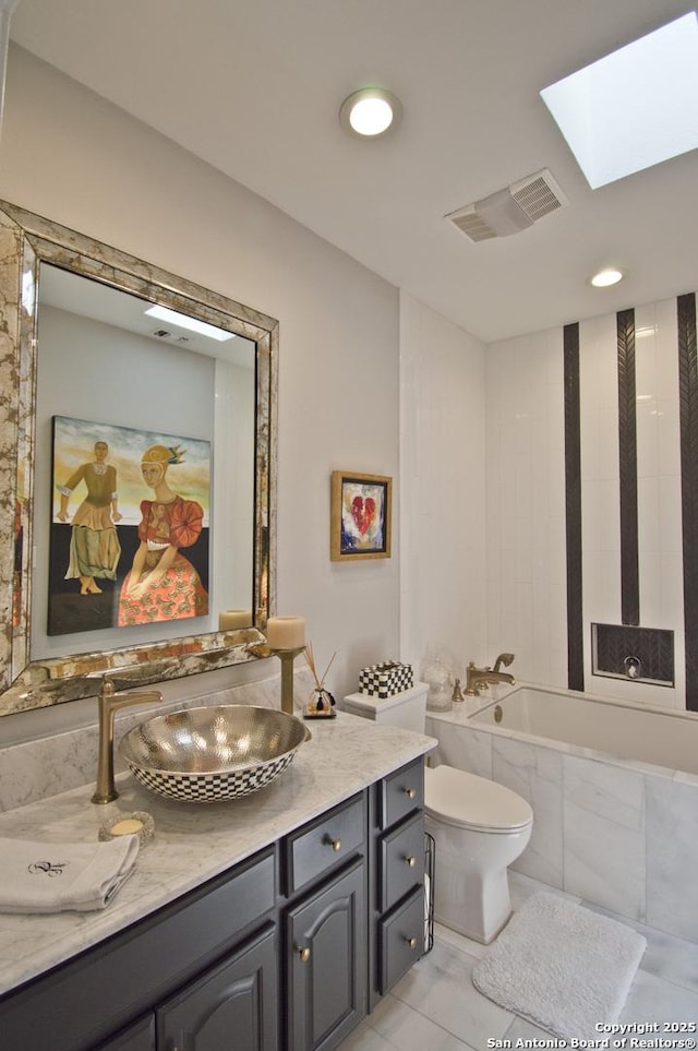 8 Kensington Ct, San Antonio, TX 78218 - bathroom featuring toilet, a skylight, tiled bath, and vanity