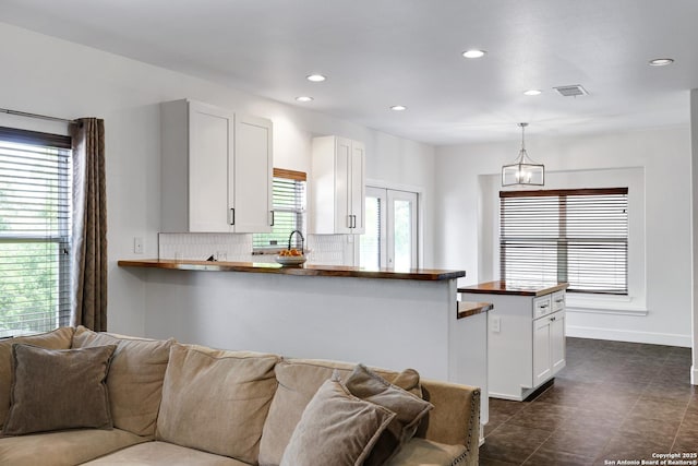 4451 Taylors Bnd, San Antonio, TX 78247 - kitchen featuring wooden counters, open floor plan, recessed lighting, white cabinets, and tasteful backsplash