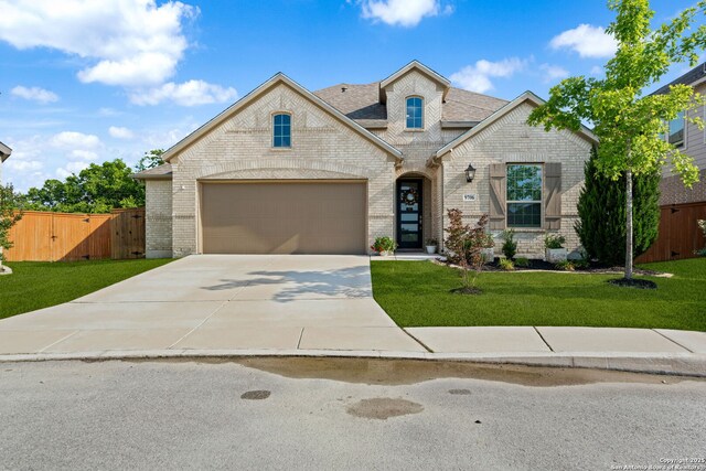 9706 Kremmen, Boerne, TX 78006 - french country home featuring driveway, brick siding, a shingled roof, and a gate