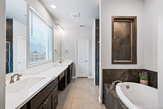 9706 Kremmen, Boerne, TX 78006 - bathroom featuring a garden tub, a shower stall, double vanity, and tile patterned flooring