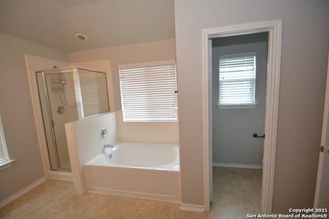 807 Maltese Gdn, San Antonio, TX 78260 - bathroom featuring a bath, a shower stall, and baseboards