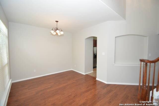 807 Maltese Gdn, San Antonio, TX 78260 - unfurnished room featuring arched walkways, wood finished floors, a chandelier, and baseboards