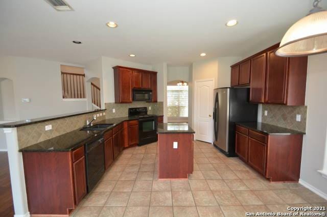 807 Maltese Gdn, San Antonio, TX 78260 - kitchen with black appliances, a sink, tasteful backsplash, a center island, and a peninsula