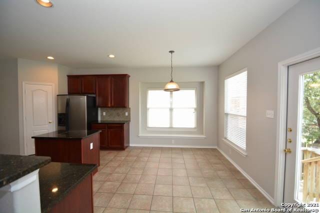 807 Maltese Gdn, San Antonio, TX 78260 - kitchen with stainless steel refrigerator with ice dispenser, decorative light fixtures, backsplash, recessed lighting, and baseboards