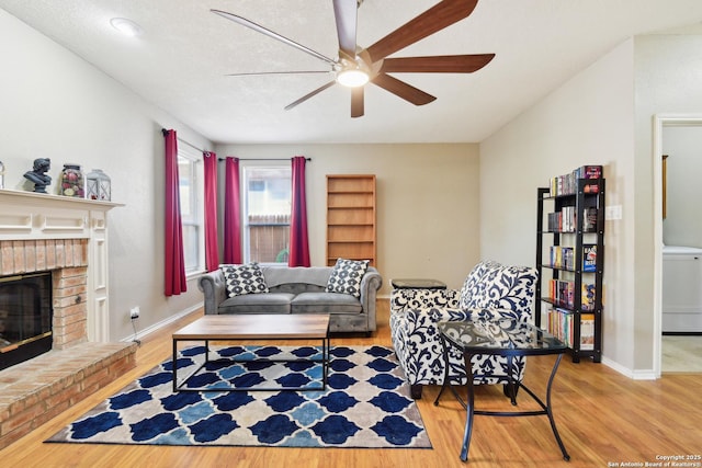 11823 Stanton, San Antonio, TX 78253 - living room with ceiling fan, wood finished floors, washer / clothes dryer, a fireplace, and baseboards