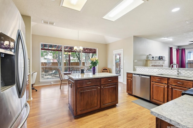 11823 Stanton, San Antonio, TX 78253 - kitchen featuring appliances with stainless steel finishes, light wood-style flooring, a sink, a chandelier, and decorative light fixtures