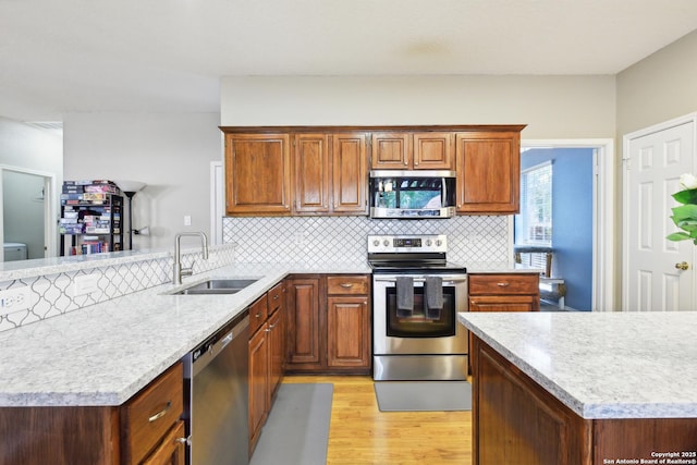 11823 Stanton, San Antonio, TX 78253 - kitchen with appliances with stainless steel finishes, a sink, light wood-type flooring, tasteful backsplash, and a peninsula