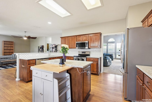 11823 Stanton, San Antonio, TX 78253 - kitchen featuring stainless steel appliances, a sink, light wood-type flooring, a peninsula, and decorative backsplash