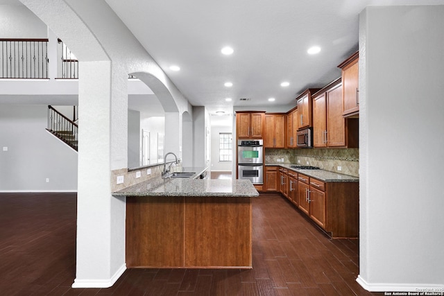 25511 Willard Path, San Antonio, TX 78261 - kitchen featuring stainless steel appliances, a sink, light stone counters, dark wood finished floors, and recessed lighting