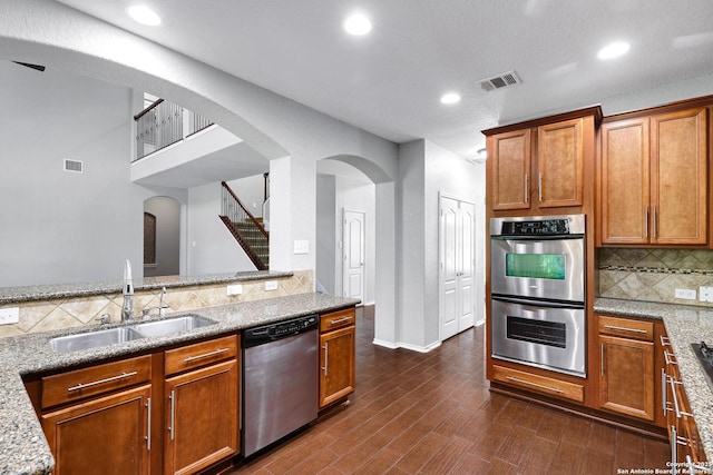 25511 Willard Path, San Antonio, TX 78261 - kitchen featuring stainless steel appliances, a sink, arched walkways, recessed lighting, and decorative backsplash