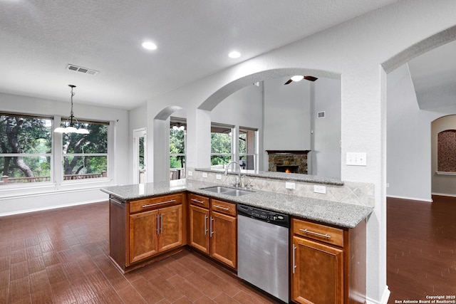 25511 Willard Path, San Antonio, TX 78261 - kitchen featuring stainless steel dishwasher, a sink, dark wood finished floors, light stone countertops, and brown cabinets