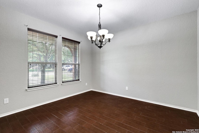 25511 Willard Path, San Antonio, TX 78261 - empty room featuring a chandelier, baseboards, and dark wood-style flooring