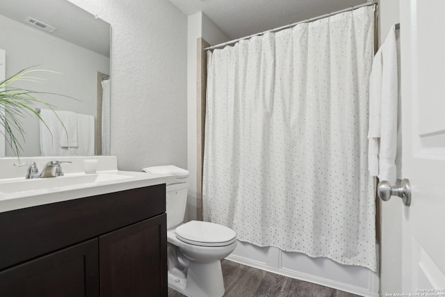 6131 Akin, San Antonio, TX 78261 - full bathroom with vanity, wood finished floors, toilet, a textured wall, and shower / bath combination with curtain