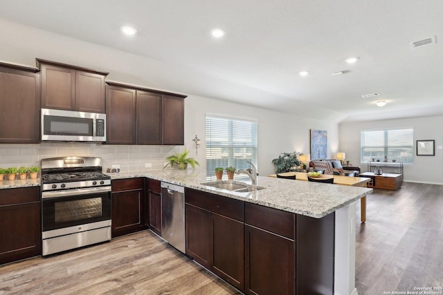 6131 Akin, San Antonio, TX 78261 - kitchen featuring stainless steel appliances, a peninsula, a sink, light wood-style flooring, and recessed lighting