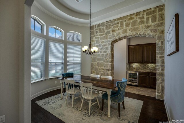 26358 Tawny Way, Boerne, TX 78015 - dining space featuring beverage cooler, a chandelier, dark wood-style flooring, ornamental molding, and arched walkways