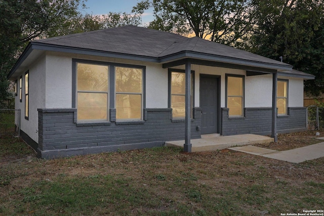 228 Quinta St, San Antonio, TX 78210 - view of front of house with brick siding, stucco siding, and roof with shingles