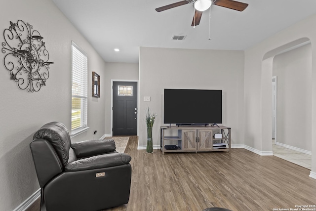 8415 Fortuna Vly, San Antonio, TX 78252 - living room with arched walkways, wood finished floors, ceiling fan, and baseboards