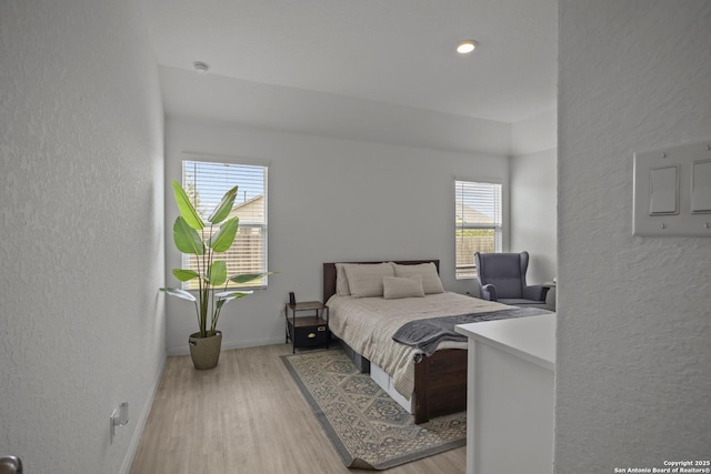 31665 Acacia Vis, Bulverde, TX 78163 - bedroom with multiple windows, a textured wall, wood finished floors, and baseboards