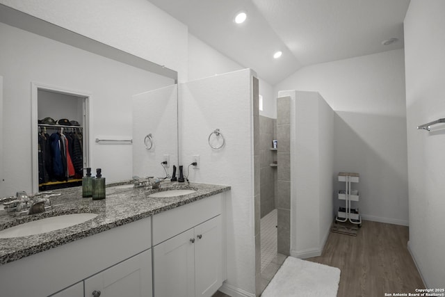 31665 Acacia Vis, Bulverde, TX 78163 - bathroom featuring double vanity, wood finished floors, walk in shower, lofted ceiling, and a walk in closet