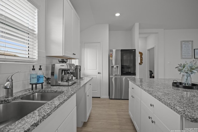31665 Acacia Vis, Bulverde, TX 78163 - kitchen with stainless steel fridge with ice dispenser, a sink, white cabinetry, light wood-type flooring, and backsplash