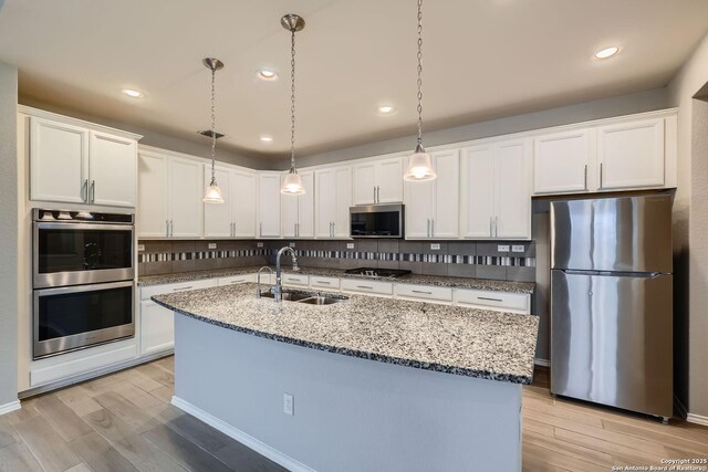 13908 Lazada, San Antonio, TX 78245 - kitchen featuring appliances with stainless steel finishes, a sink, decorative backsplash, white cabinetry, and recessed lighting