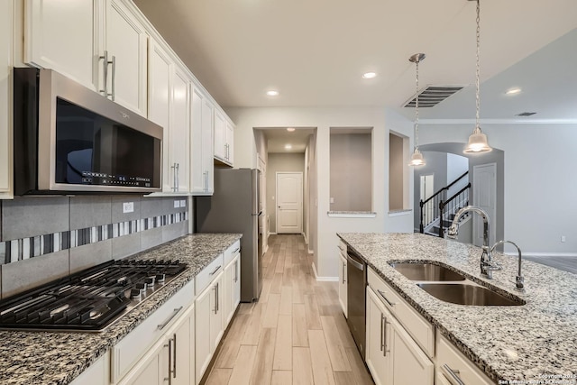 13908 Lazada, San Antonio, TX 78245 - kitchen featuring stainless steel appliances, a sink, baseboards, light wood finished floors, and backsplash