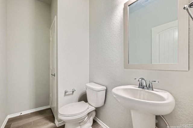 13908 Lazada, San Antonio, TX 78245 - half bathroom with wood finished floors, toilet, and baseboards