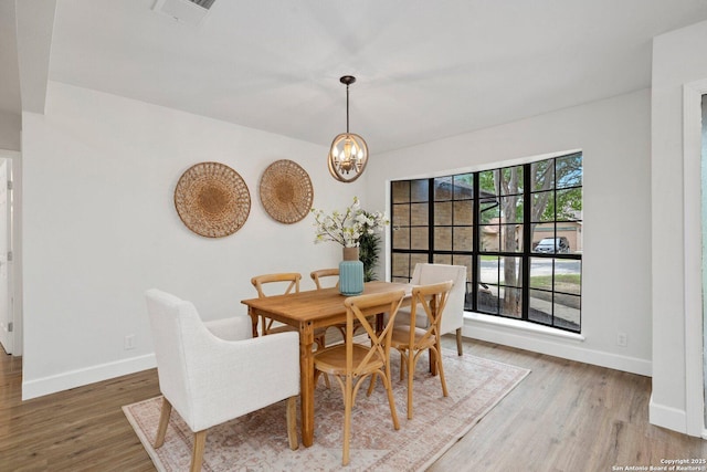7527 Rustic Trl, San Antonio, TX 78244 - dining area with baseboards, light wood finished floors, and a chandelier