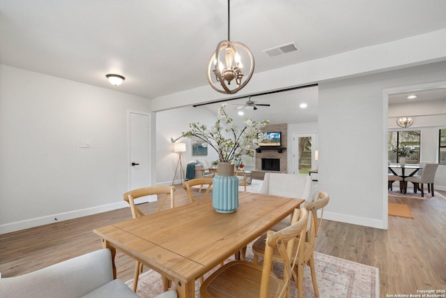 7527 Rustic Trl, San Antonio, TX 78244 - dining area with a chandelier, a ceiling fan, baseboards, and light wood-style flooring