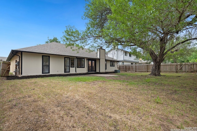 7527 Rustic Trl, San Antonio, TX 78244 - rear view of property featuring a chimney, a shingled roof, and central AC unit