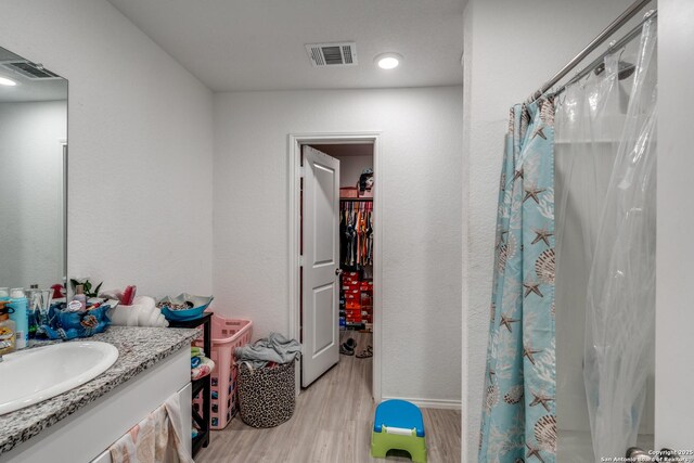 10827 Hernando Ct, Converse, TX 78109 - full bath with wood finished floors, vanity, and curtained shower