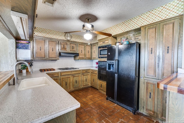 10745 Rosemar Ln, Adkins, TX 78101 - kitchen with black appliances, a sink, wallpapered walls, under cabinet range hood, and light countertops