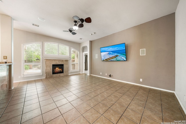 102 Blue Thorn, San Antonio, TX 78256 - unfurnished living room featuring a tile fireplace, a ceiling fan, light tile patterned flooring, and baseboards