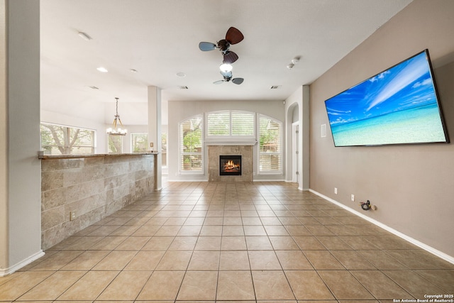 102 Blue Thorn, San Antonio, TX 78256 - unfurnished living room with a ceiling fan, healthy amount of natural light, light tile patterned floors, and a tile fireplace