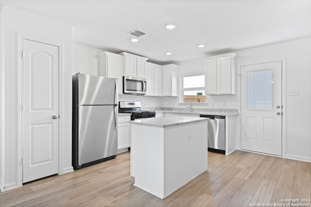 12055 Luckey Villa, San Antonio, TX 78252 - kitchen with stainless steel appliances, white cabinets, a kitchen island, light wood-style flooring, and recessed lighting