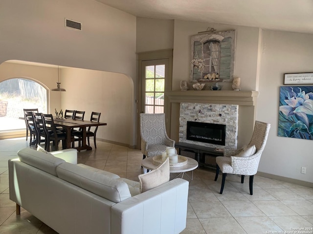 12111 Woodsrim, Live Oak, TX 78233 - living room featuring light tile patterned floors, a stone fireplace, baseboards, and high vaulted ceiling