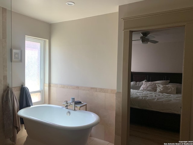 12111 Woodsrim, Live Oak, TX 78233 - ensuite bathroom with a soaking tub, ceiling fan, tile walls, and wainscoting