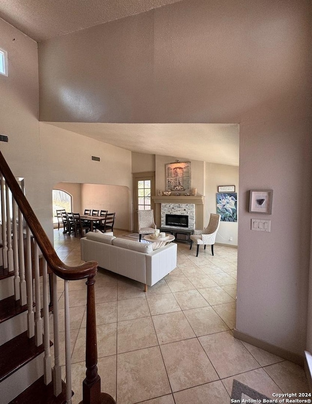 12111 Woodsrim, Live Oak, TX 78233 - living room featuring light tile patterned flooring, a textured ceiling, a fireplace, stairs, and baseboards