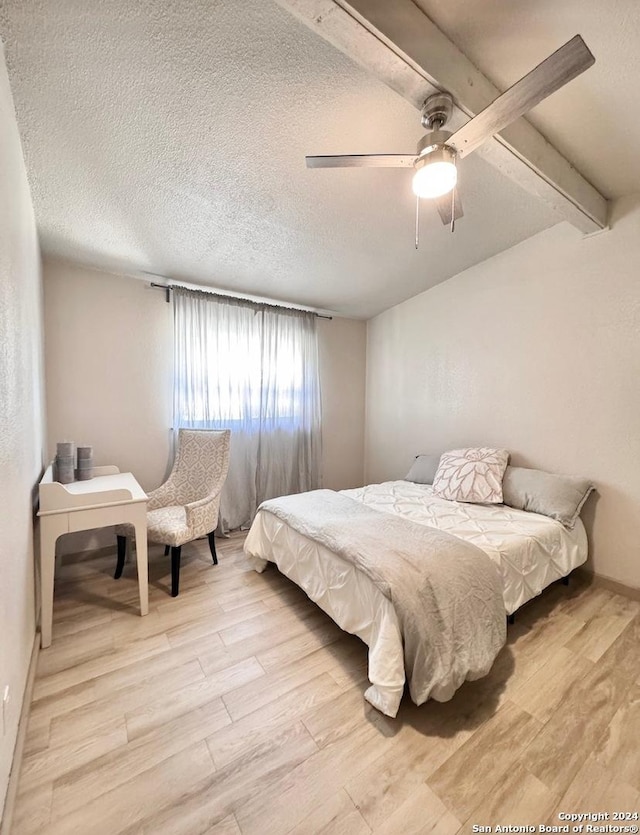12111 Woodsrim, Live Oak, TX 78233 - bedroom featuring light wood-style floors, a textured ceiling, ceiling fan, beam ceiling, and baseboards