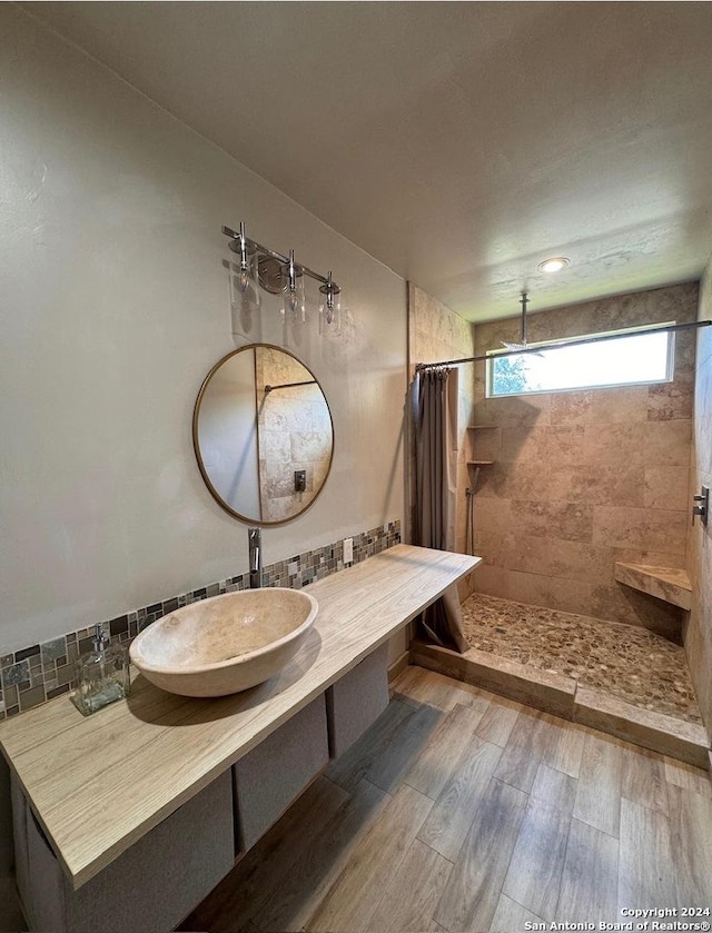 12111 Woodsrim, Live Oak, TX 78233 - full bath featuring tiled shower, tasteful backsplash, wood finished floors, and vanity