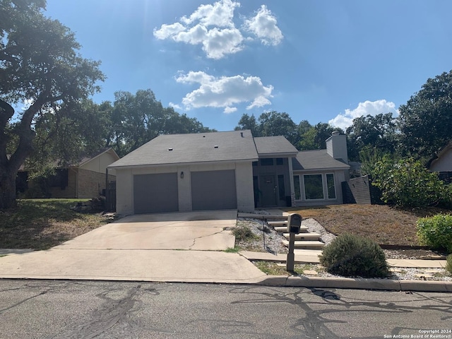 12111 Woodsrim, Live Oak, TX 78233 - view of front facade with an attached garage, concrete driveway, and a chimney