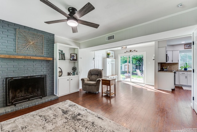 3618 Minthill, San Antonio, TX 78230 - living area with wood finished floors, ceiling fan, plenty of natural light, a brick fireplace, and ornamental molding
