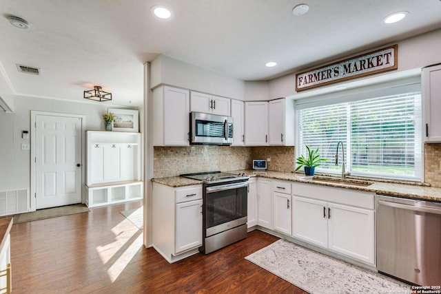 3618 Minthill, San Antonio, TX 78230 - kitchen with stainless steel appliances, a sink, dark wood-style floors, white cabinetry, and tasteful backsplash