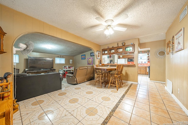 3211 Hatton, San Antonio, TX 78237 - dining area featuring arched walkways, a ceiling fan, a textured ceiling, light tile patterned flooring, and baseboards