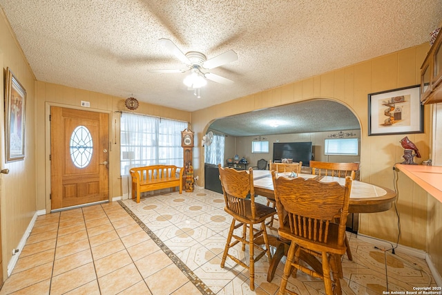3211 Hatton, San Antonio, TX 78237 - dining room with arched walkways, a ceiling fan, a textured ceiling, light tile patterned floors, and plenty of natural light